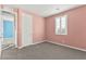 Neutral bedroom featuring gray carpet, pink walls, bright window, and a white door at 424 Vigo Port St, Las Vegas, NV 89138