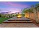 Elegant brick-paved fire pit area featuring a built-in fire feature and landscape lighting at 424 Vigo Port St, Las Vegas, NV 89138