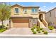 Charming two-story home with a two-car garage, stone accents, landscaped yard, and covered entryway at 424 Vigo Port St, Las Vegas, NV 89138