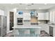 Modern kitchen with blue accents, white cabinetry, stainless steel appliances, and a center island at 424 Vigo Port St, Las Vegas, NV 89138