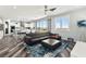Living room with hardwood floors, sectional sofa, and access to kitchen, dining, and outdoor views at 424 Vigo Port St, Las Vegas, NV 89138