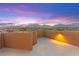 A private rooftop deck offers an open space with ambient lighting against a stunning sunset and mountain view backdrop at 424 Vigo Port St, Las Vegas, NV 89138