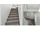 Carpeted staircase with white handrail connecting the first and second floors of this home at 424 Vigo Port St, Las Vegas, NV 89138