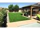 Lush green backyard with a covered patio, ideal for outdoor entertaining and relaxation at 4242 Helena Hideaway Ct, Las Vegas, NV 89129