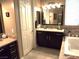 Bathroom featuring dark cabinets, decorative backsplash, vanity and soaking tub at 4242 Helena Hideaway Ct, Las Vegas, NV 89129