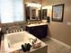 Bright bathroom featuring a soaking tub, dark vanity, and natural light at 4242 Helena Hideaway Ct, Las Vegas, NV 89129