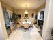 Bright dining room with tile floors, an elegant chandelier, and a round dining table at 4242 Helena Hideaway Ct, Las Vegas, NV 89129