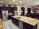 Gourmet kitchen featuring dark wood cabinetry, stainless steel appliances and a large island at 4242 Helena Hideaway Ct, Las Vegas, NV 89129