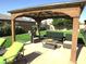 Charming covered patio with comfortable seating, perfect for enjoying the serene backyard views at 4242 Helena Hideaway Ct, Las Vegas, NV 89129