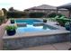 Outdoor pool and hot tub area with lounge seating and manicured landscaping at 4242 Helena Hideaway Ct, Las Vegas, NV 89129