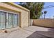 A cozy backyard with sliding doors, a stucco wall, and palm trees in the background at 45 N Lamb Blvd, Las Vegas, NV 89110