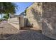 Side yard features a textured wall, gravel landscape, and a small blue gate at 45 N Lamb Blvd, Las Vegas, NV 89110