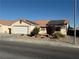 Charming single-story home with a two-car garage, desert landscaping, and roof-mounted solar panels at 4636 Ferrell St, North Las Vegas, NV 89031