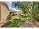 Lush backyard featuring mature trees, a well-manicured lawn, and a charming water feature at 467 Beardsley Cir, Henderson, NV 89052