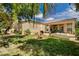 Inviting backyard with lush landscaping, mature trees, patio, and a soothing water feature at 467 Beardsley Cir, Henderson, NV 89052
