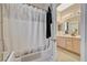 Well-lit bathroom featuring a shower-tub combo with white and silver shower curtain at 467 Beardsley Cir, Henderson, NV 89052