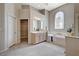 Bright bathroom featuring a soaking tub under a stained glass window and large vanity at 467 Beardsley Cir, Henderson, NV 89052