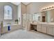 Bright bathroom featuring a soaking tub under a stained glass window and a glass enclosed shower at 467 Beardsley Cir, Henderson, NV 89052