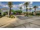 Elegant gated community entrance with lush landscaping, manicured shrubs and towering palm trees at 467 Beardsley Cir, Henderson, NV 89052