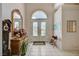 Inviting foyer with tile floors and an arched transom window over the glass double doors at 467 Beardsley Cir, Henderson, NV 89052