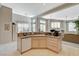 Well-lit kitchen with granite countertops, a breakfast bar, and view to the living room at 467 Beardsley Cir, Henderson, NV 89052