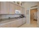 Kitchen cabinets with modern appliances and a view to the hallway at 467 Beardsley Cir, Henderson, NV 89052
