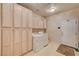 Well-organized laundry room with washer, dryer, and ample storage at 467 Beardsley Cir, Henderson, NV 89052