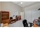 Home office featuring a ceiling fan, shelves and dark wooden furniture at 467 Beardsley Cir, Henderson, NV 89052