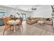 Open-concept living and dining area with wood-look floors and a modern ceiling fan at 4735 Madrigal Way, Las Vegas, NV 89122