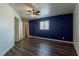 Bedroom with wood laminate flooring, a dark blue accent wall, and ceiling fan at 499 Kristin Ln, Henderson, NV 89011