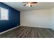 A bedroom with wood floors and a dark blue accent wall with natural light from the window at 499 Kristin Ln, Henderson, NV 89011