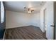 An open bedroom space with wood laminate flooring, a ceiling fan, and neutral white walls at 499 Kristin Ln, Henderson, NV 89011