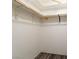 Walk-in closet with wood floors and installed white metal and wood clothing racks at 499 Kristin Ln, Henderson, NV 89011