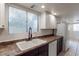 Spacious kitchen area featuring white cabinets and appliances, and double basin sink with a modern faucet at 499 Kristin Ln, Henderson, NV 89011