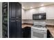 Charming kitchen with black and white cabinetry, a white oven, and stylish chalkboard art at 499 Kristin Ln, Henderson, NV 89011