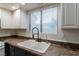 Bright kitchen featuring a double basin sink with a modern black faucet and white cabinets at 499 Kristin Ln, Henderson, NV 89011