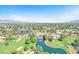 Scenic aerial view of a golf course community featuring a tranquil pond and meticulously manicured grounds at 5216 Desert Star Dr, Las Vegas, NV 89130