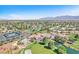 Expansive aerial view of community showcasing golf course, tennis courts, pool, clubhouse, and lush surroundings at 5216 Desert Star Dr, Las Vegas, NV 89130