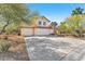 Two-story home with a three-car garage, desert landscaping and a concrete driveway at 5216 Desert Star Dr, Las Vegas, NV 89130