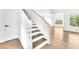 Staircase with wooden steps, white risers, and a wooden handrail, leading to a spacious living area at 5216 Desert Star Dr, Las Vegas, NV 89130