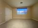 Bright bedroom with carpet, a window, and sliding-door closet at 5376 S Conquistador St, Las Vegas, NV 89148