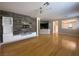 Open-concept living room with hardwood floors, large windows, and a modern decorative stone panel wall at 5376 S Conquistador St, Las Vegas, NV 89148