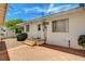 The back of the house has a small step area, bushes, a window, and a brick patch at 557 6Th St, Boulder City, NV 89005