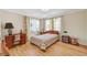 Bright bedroom with hardwood floors, large windows with sheer curtains, and vintage furniture at 557 6Th St, Boulder City, NV 89005