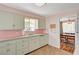 Charming kitchen featuring pastel pink countertops, a double basin sink, and plentiful cabinet space at 557 6Th St, Boulder City, NV 89005