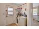 Practical utility room with washer, water heater, storage shelf and access door at 557 6Th St, Boulder City, NV 89005