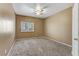 The cozy bedroom includes neutral carpeting, a ceiling fan, and ample natural light from a window at 5655 E Sahara Ave # 1052, Las Vegas, NV 89142