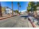Community entrance with manicured landscaping, mature trees, and a secure gate at 5655 E Sahara Ave # 1052, Las Vegas, NV 89142