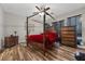 Elegant bedroom with a four-poster bed, wood floors, and large dresser at 5745 Sagamore Canyon St, North Las Vegas, NV 89081
