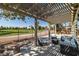 Covered patio seating area overlooking well-manicured backyard landscaping and golf course in the distance at 5747 Jaborandi Ave, Pahrump, NV 89061